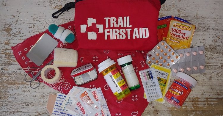 A neatly packed family hiking backpack with water bottles, snacks, and a first-aid kit